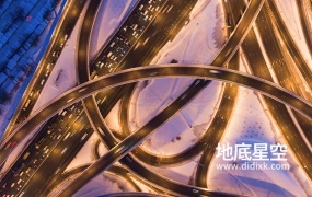 视频素材-鸟瞰车辆行驶在冬季傍晚照亮的交叉路口立交桥