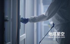 视频素材-身穿防护服的男士在进行消毒擦拭门把手
