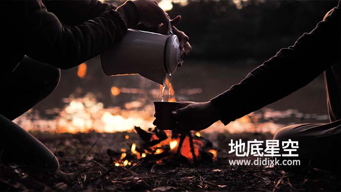 视频素材-人们在篝火旁倒一杯热饮视频